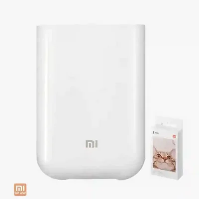 پرینتر عکس قابل حمل Xiaomi XMKDDYJ01HT با کاغذ چاپ پرینتر عکس بی سیم شیائومی XMKDDYJ01HT سفید کنار بسته کاغذ عکس گربه
