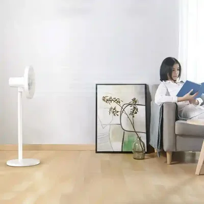پنکه ایستاده شیائومی مدل Mijia JLLDS01DM کنار فرد در حال مطالعه