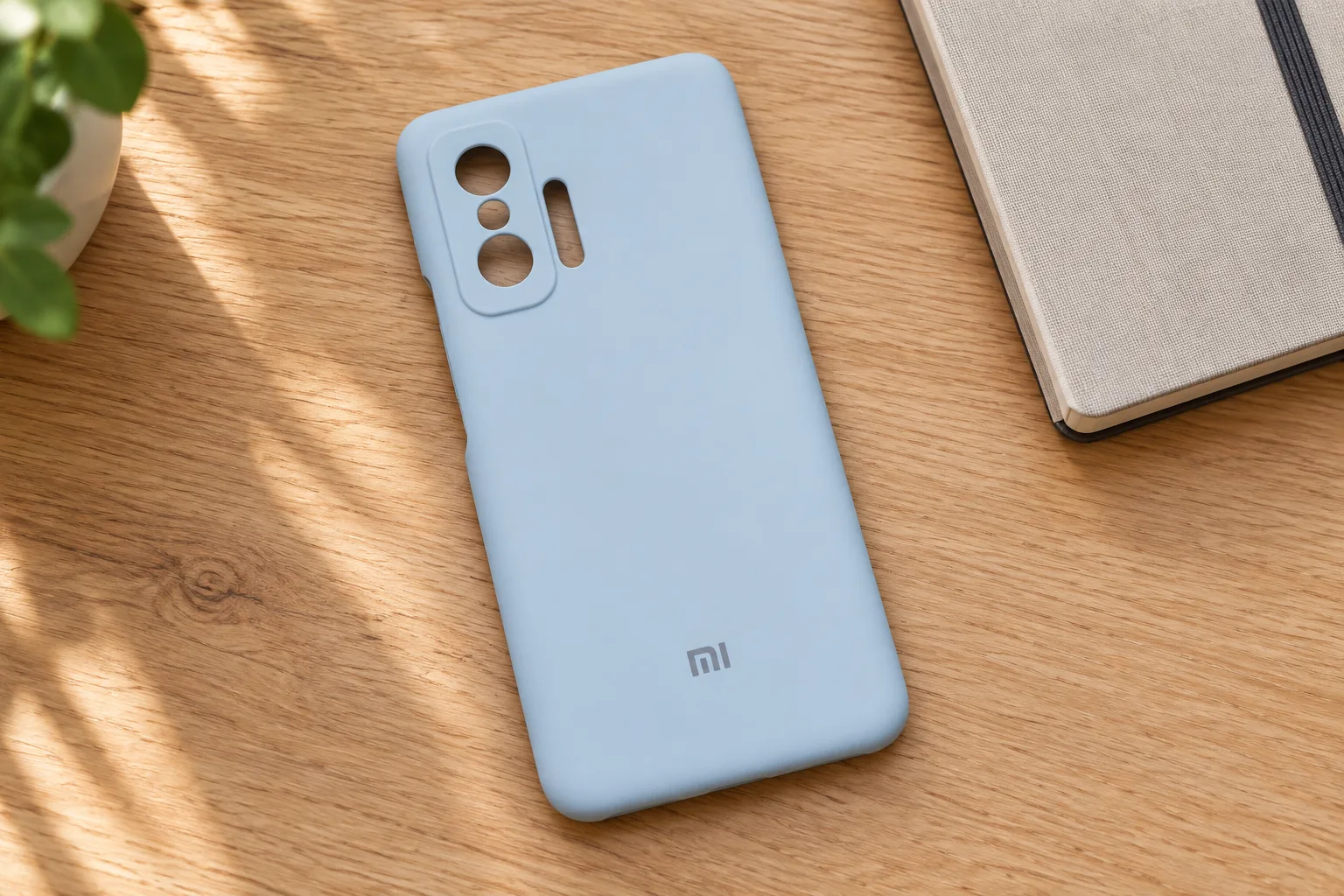 تصویرسازی کاور آبی کم‌رنگ Xiaomi 11T روی میز چوبی، با نمایش برش‌های دوربین